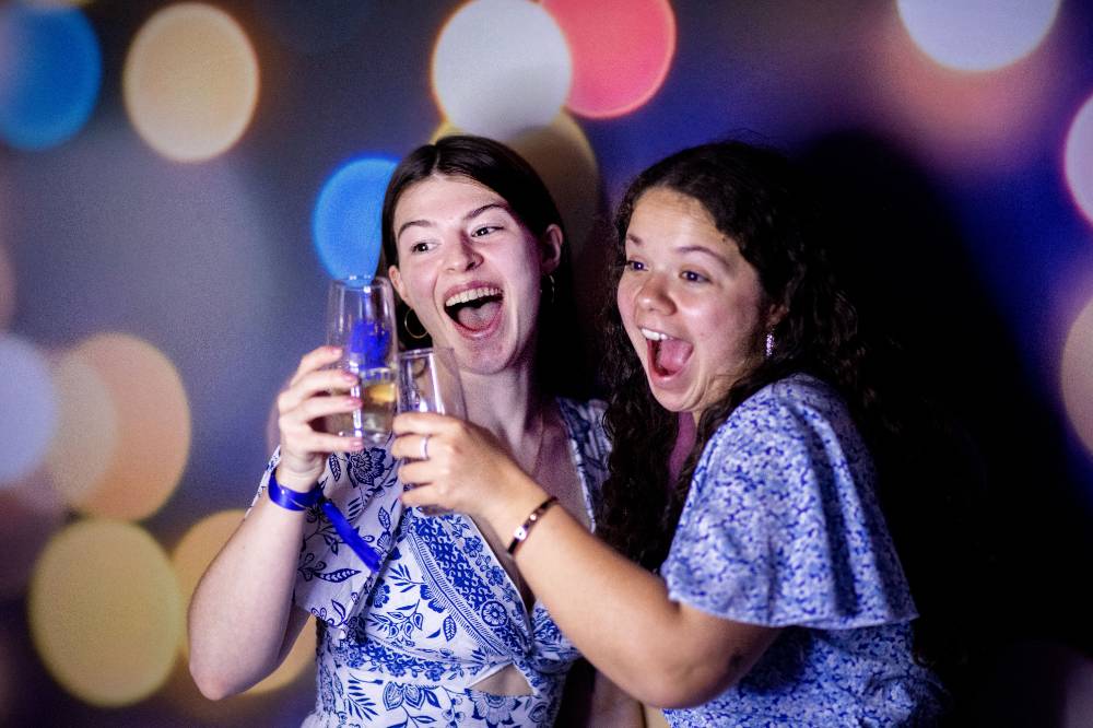 Two grads celebrating with their champagne flutes.